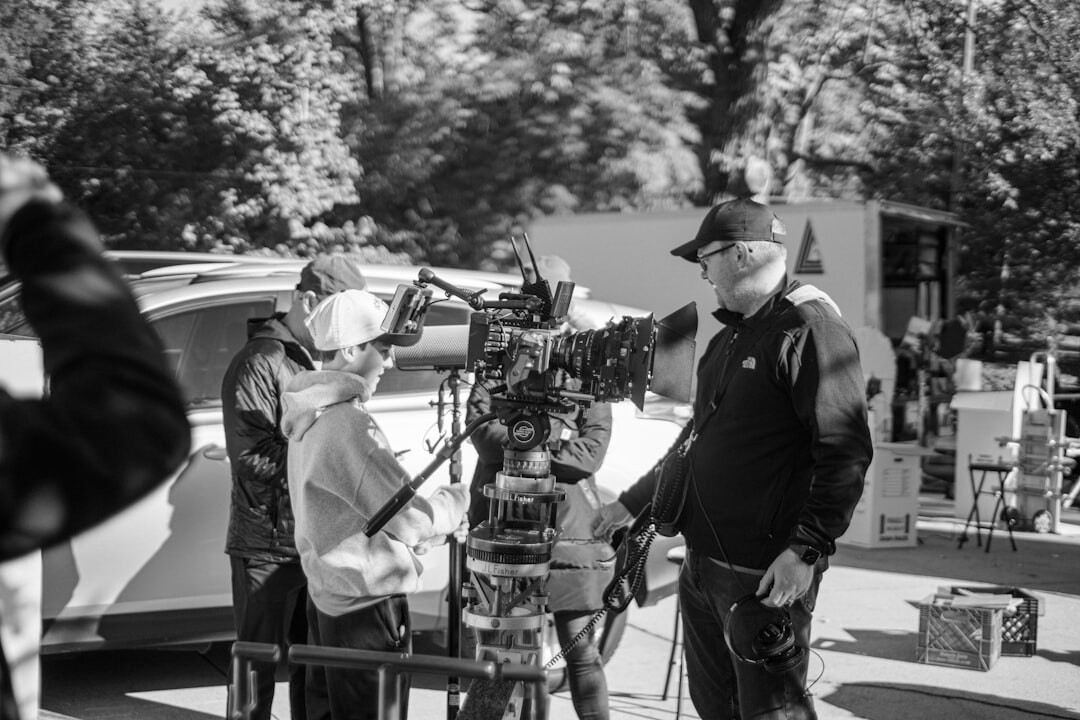 Broadcast crew setting up camera equipment beside a production van