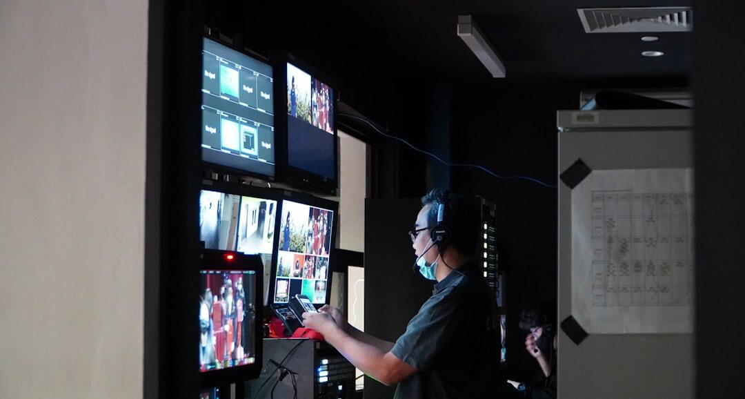 Broadcast technician monitoring a wall of live camera feed screens