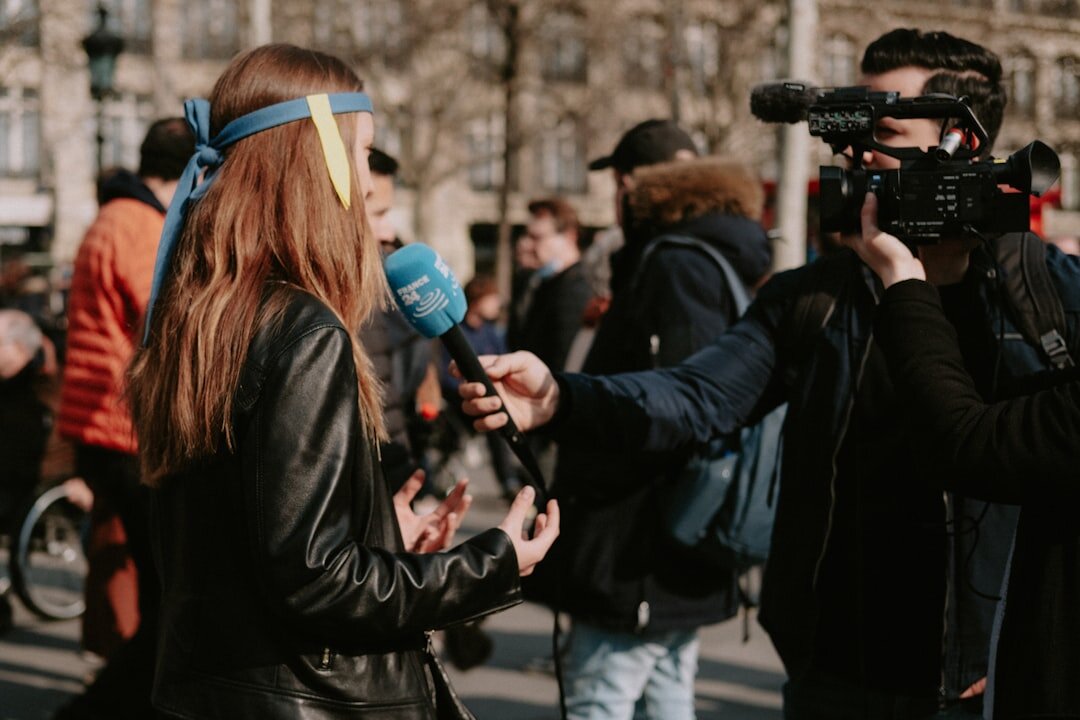 Female reporter speaking into a microphone while reporting live on location
