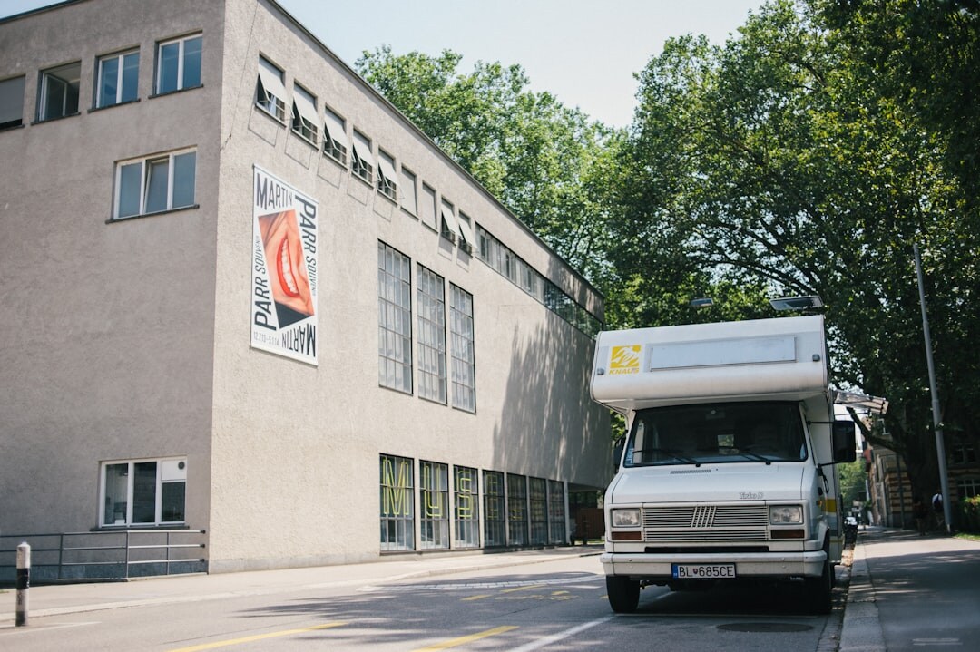 Satellite broadcast truck with a raised dish parked outside a building